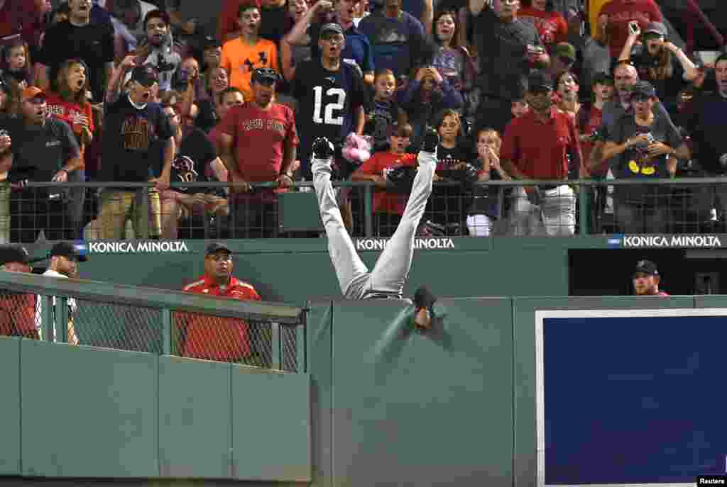Cleveland Indians center fielder Austin Jackson (26) falls over the wall after making a catch to rob Boston Red Sox designated hitter Hanley Ramirez (not pictured) of a home run during the fifth inning at Fenway Park in Boston, Massachusetts. (Credit: Bob DeChiara/USA TODAY Sports)