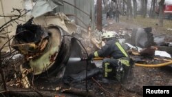 A firefighter extinguishes the remains of a missile, which Ukrainian authorities and other investigators said was made in North Korea, at the site of a Russian strike in Kharkiv on Jan. 2, 2024.