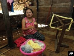 FILE - Mu Pro, a 42-year-old Karen refugee weaves while being interviewed at Mae La refugee camp in Ta Song Yang district of Tak province, northern Thailand, April 12, 2013.