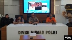 Tersangka SDA (kanan) menyampaikan permohonan maaf kepada publik. (VOA/RIo Tuasikal)