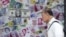 FILE - A man walks past an advertisement promoting China's renminbi (RMB) or yuan, U.S. dollar and Euro exchange services at foreign exchange store in Hong Kong, China, Aug. 13, 2015. 