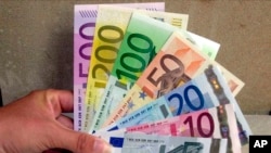 Seorang karyawan di Bank Sentral di Hanover, Jerman utara, memegang mata uang Euro, 30 Agustus 2001 (Foto: AP)