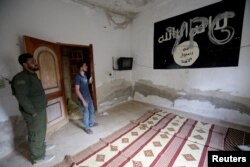 YPG (Unit Perlindungan Rakyat Kurdi) terlukis di dinding bendera ISIS di sebuah rumah di Tal Abyad, Suriah, 16 Oktober 2019. (Foto: REUTERS/Khalil Ashawi)