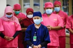 Para tenaga medis mengenakan masker pelindung berdoa untuk para pasien virus corona (Covid-19) saat pengarahan di ruang gawat darurat di rumah sakit, 14 Mei 2020. (Foto: Reuters)