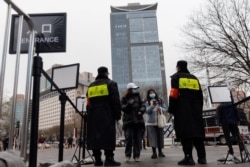 北京一个商场的入口处保安查看顾客的手机健康码。（2021年11月29日）