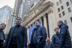 中国贪腐跨越国境，据信大量资本流入美国并融入金融体系。美国政府已经加大了追踪力度。图为来自中国的访客于2018年12月4日星期二在纽约证券交易所观望。(美联社资料)