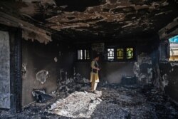 Seorang personel keamanan Afghanistan memeriksa sebuah gedung di lokasi ledakan bom mobil di Kabul pada 4 Agustus 2021. (Foto: WAKIL KOHSAR / AFP)