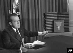 FILE - President Richard M. Nixon is shown pointing to the transcripts of the White House tapes in this April 29, 1974 photo, after he announced during a nationally-televised speech that he would turn over the transcripts to House impeachment invesigators