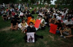 "Seorang aktivis hak-hak perempuan meletakkan lilin di samping poster bergambar Noor Mukadam, yang baru-baru ini dipenggal, untuk memberi penghormatan kepada Noor dan korban kekerasan dalam rumah tangga lainnya, di Islamabad, Pakistan. (Foto: AP)