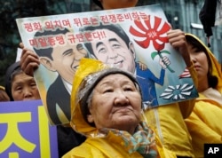 FILE - Former comfort woman Kil Un-ock who was forced to serve for the Japanese troops as a sexual slave during World War II, attends a rally against a visit by Japanese Prime Minster Shinzo Abe, in front of the Japanese Embassy in Seoul, South Korea.
