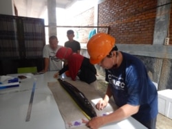 Peneliti Fadly Y. Tantu dan Jusri Nilawati pada Fakultas Peternakan dan Perikanan UNTAD menyiapkan pemasangan tanda pada ikan sidat Anguilla marmorata yang akan di lepas ke Perairan Sungai Poso. Sabtu, 27 Februari 2021. (Foto: Fadly Y. Tantu)