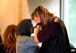 A young woman comforts a crying man outside the courtroom after Jeremy Christian was arraigned in Portland, Ore., May 30, 2017.