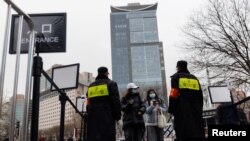 北京一个商场的入口处保安查看顾客的手机健康码。（2021年11月29日）