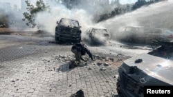 FILE - An Israeli police officer investigates at the scene where a rocket fired from Lebanon landed in Israel, amid cross-border hostilities between Hezbollah and Israel, near Israel's border with Lebanon in northern Israel, Oct. 7, 2024.