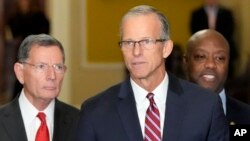 Newly-elected Senate Majority Leader Sen. John Thune, R-S.D., center, flanked by Sen. John Barrasso, R-Wyo., left, and Sen. Tim Scott, R-S.C., right, speaks at a news conference on Capitol Hill, Nov. 13, 2024, in Washington.