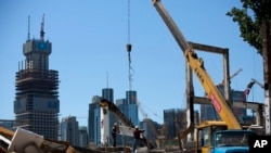 中国工人在北京商业区修建新建筑。（2015年6月30日）