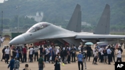 Visitors look at the Chinese military's J-16D electronic warfare airplane during 13th China International Aviation and Aerospace Exhibition, also known as Airshow China 2021, on Wednesday, Sept. 29, 2021, in Zhuhai in southern China's Guangdong province. 