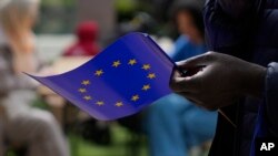 Seorang pria memegang bendera Uni Eropa saat berjalan di luar gedung Komisi Eropa selama perayaan Hari Eropa di Brussels pada 4 Mei 2024. (Foto: AP)