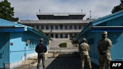 资料照片:联合国军司令部(UNC)士兵(右)和一名韩国士兵(左)在联合安全区(JSA)板门店分隔朝鲜和韩国的军事分界线前站岗。2022年10月4日拍摄。 (法新社图片)