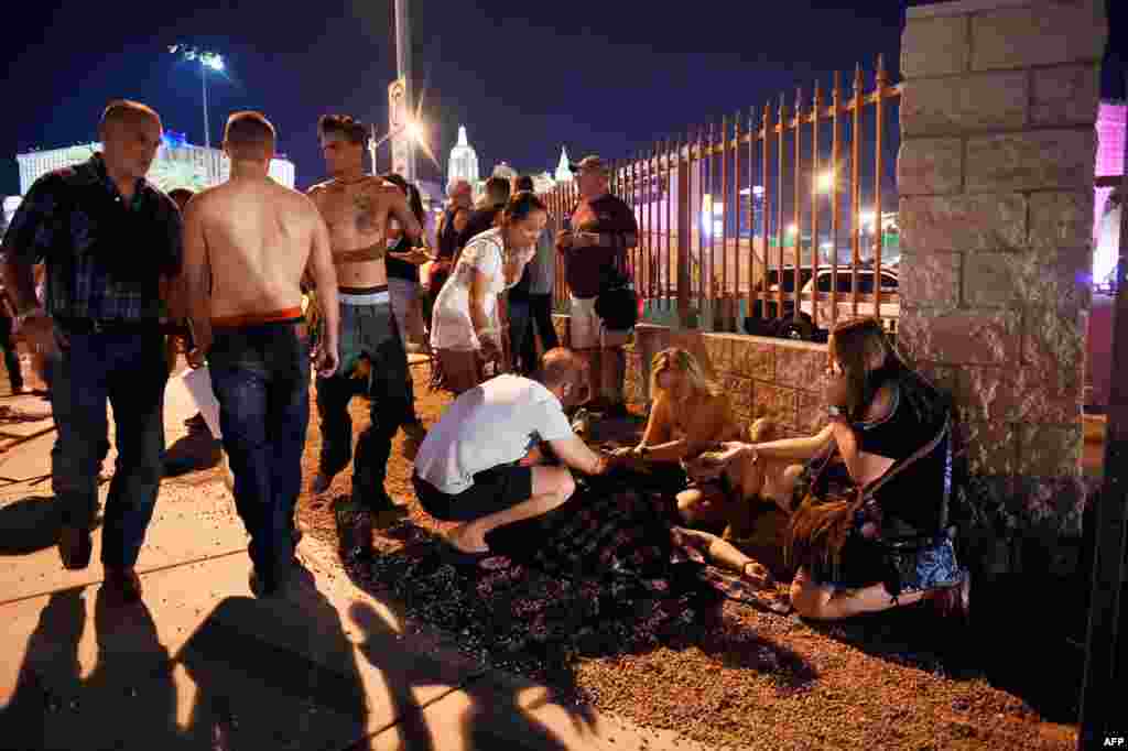 People tend to the wounded outside the Route 91 Harvest Country music festival grounds after an apparent shooting on Oct. 1, 2017 in Las Vegas, Nevada.