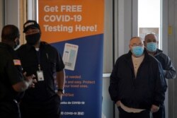 People stand in line to be tested for the coronavirus disease (COVID-19), at a test center at the Staten Island Ferry Terminal in Staten Island, New York, Nov. 12, 2020.