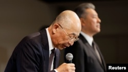 Daihatsu Motor President Soichiro Okudaira, flanked by Toyota Motor Executive Vice President Hiroki Nakajima, bows at the start of a news conference in Tokyo, Japan, Dec. 20, 2023. 