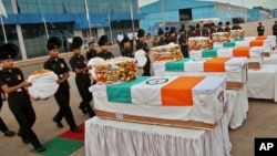 Indian soldiers pay tribute to their colleagues after their remains were returned at a wreath laying ceremony at the Palam Technical Airport in New Delhi, India, Aug. 7, 2013.