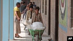 Warga Yaman menerima bantuan makanan dari Badan Pangan Dunia, di sebuah sekolah di Sanaa, Yaman, 25 Agustus 2019. (Foto: AP)