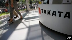 Pengunjung melewati kantor Takata Corp. (Foto:do)