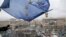 FILE - A supporter waves a European Union flag from a building top in Kyiv, Nov. 29, 2013.