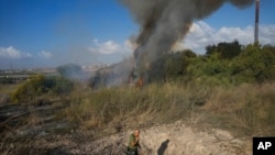 以色列中部一块空地在2024年9月15日遭胡塞武装导弹袭击后起火。