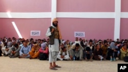 一名塔利班士兵在阿富汗加兹尼市看守一群阿富汗保安部队成员。（2021年8月13日）