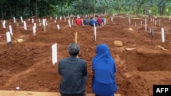 Kerabat korban virus corona (COVID-19) berdoa saat pemakaman di Jakarta, 15 April 2020. (Foto: Bayu Ismoyo/AFP)