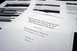 FILE - Some redacted pages of Robert Mueller's report are seen on the witness table in the House Intelligence Committee hearing room on Capitol Hill, in Washington, April 18, 2019.