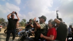 FILE - Palestinians transport Adina Moshe from her home in Kibbutz Nir Oz to the Gaza Strip, Oct. 7, 2023. The 72-year-old Israeli woman held captive by Hamas militants told an Israeli TV channel Jan. 24, 2024, that she was held at length in a dark, humid tunnel.