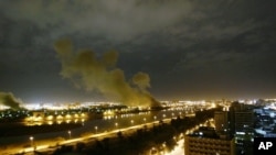 Asap membubung dari kantor Kementerian Perdagangan Irak di Baghdad setelah dihantam misil dalam serangan yang dipimpin oleh Amerika Serikat (AS) 20 Maret 2003. (Foto: Jerome Delay/AP Photo)
