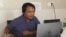 FILE - Sai Zaw Thaike, a photojournalist for the independent news website Myanmar Now, works at his desk in Yangon, Myanmar, in August 2020.