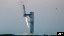  ຍານຂົນສົ່ງ ຊຸບເປີ້ເຮຟວີ ຂອງ ສຕາຣຊິບ ຖືກຢຶດໄວ້ທີີີ່ແທ່ນປ່ອຍຈະຫຼວດໃນຖານທັບດາວໄກ້ກັບ ໂບກາຊິກາ ລັດເທັກຊັສ ເມື່ອວັນທີ 13 ຕຸລາ 2024 ໃນລະຫວ່າງການທົດລອງຍານອາວະກາດ Starship Flight 5 