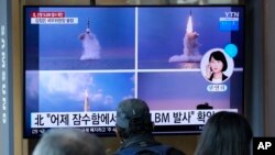 FILE - People watch a TV screen showing images of North Korea's ballistic missile launch from a submarine, during a news program at Seoul Railway Station in Seoul, South Korea, Oct. 20, 2021. 