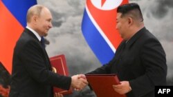 Vladimir Putin i Kim Džong Un posle potpisivanja sporazuma u Pjongjangu
(Photo by Kristina Kormilitsyna / POOL / AFP) 