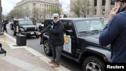 FILE - Chef Jose Andres gets ready with members of his World Central Kitchen team to load meals to deliver to needy people in downtown Washington, March 31, 2020.