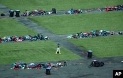 2017年10月6日，美国一名FBI人员在拉斯维加斯走过堆满了私人物品的大规模枪击案案发现场。枪击案发生于10月1日，枪手帕多克从酒店高楼层朝著室外音乐会的民众开枪，造成数十人死亡，数百人受伤。