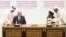 FILE - In this Feb. 29, 2020, photo, U.S. peace envoy Zalmay Khalilzad, left, and Mullah Abdul Ghani Baradar, the Taliban's top political leader, sign a peace agreement between Taliban and U.S. officials in Doha, Qatar. 