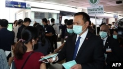 泰国公共卫生部长阿努丁在曼谷的一个高架轻轨车站发放疫情防护口罩。（2020年2月7日）