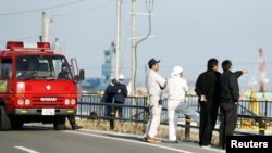 救火队员和福岛当地居民在海啸预警之后观察海水水位（2016年11月22日）