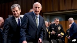 FILE - Director of National Intelligence Dan Coats, center, arrives for a hearing in Washington, Feb. 13, 2018. At left is FBI Director Christopher Wray.