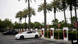 FILE - Kendaraan listrik Tesla di stasiun pengisian daya di Anaheim, California, 9 Juni 2023. Penjualan kendaraan listrik diperkirakan mencapai rekor sembilan persen dari seluruh kendaraan penumpang di AS tahun ini, menurut Kebijakan Publik Atlas. (AP/Jae C. Hong)