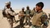 FILE - A U.S. Marine, left, shakes hands with an Afghan National Army soldier, during a training exercise in Helmand province, Afghanistan, July 5, 2017. 