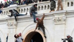 Pristalice predsednika Trampa penju se na balkon zgrade Kapitola, 6. januara 2021.