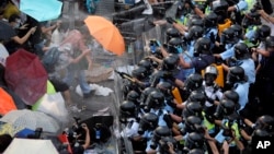 示威民众面打着雨伞对抗警察胡椒喷雾